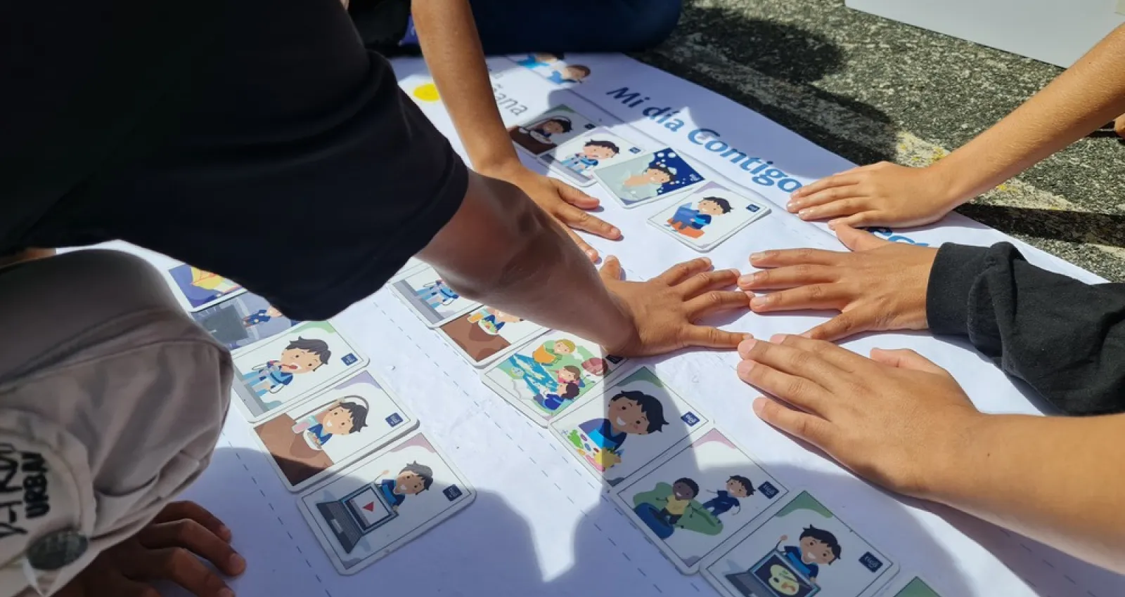 Imagen de niños juntando sus manos en una cartulina