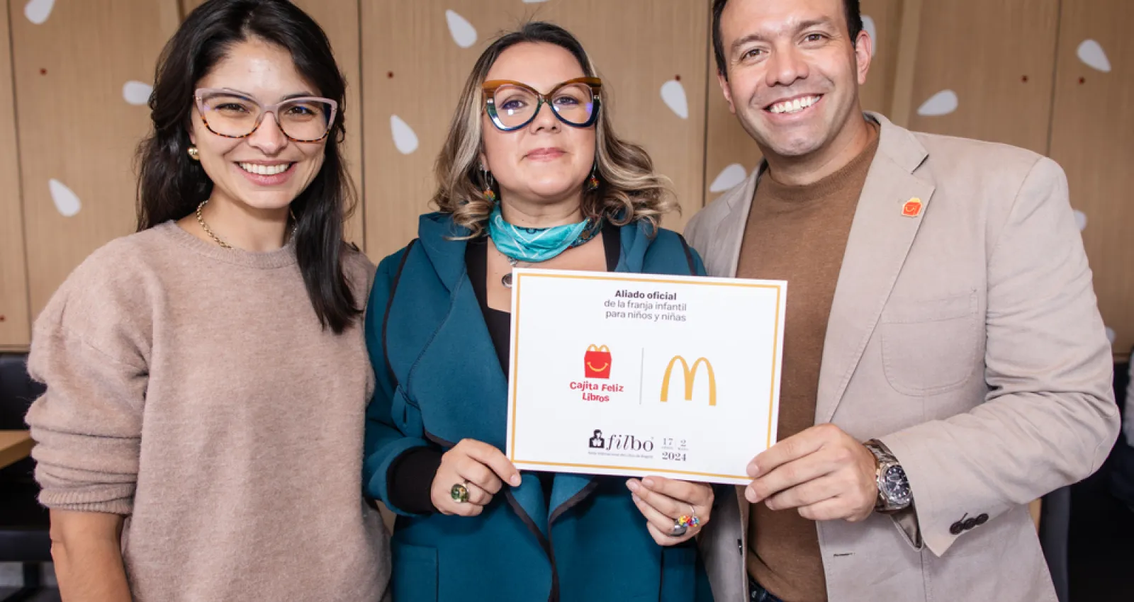 Foto de tres personas, dos mujeres y un hombre posando para la cámara