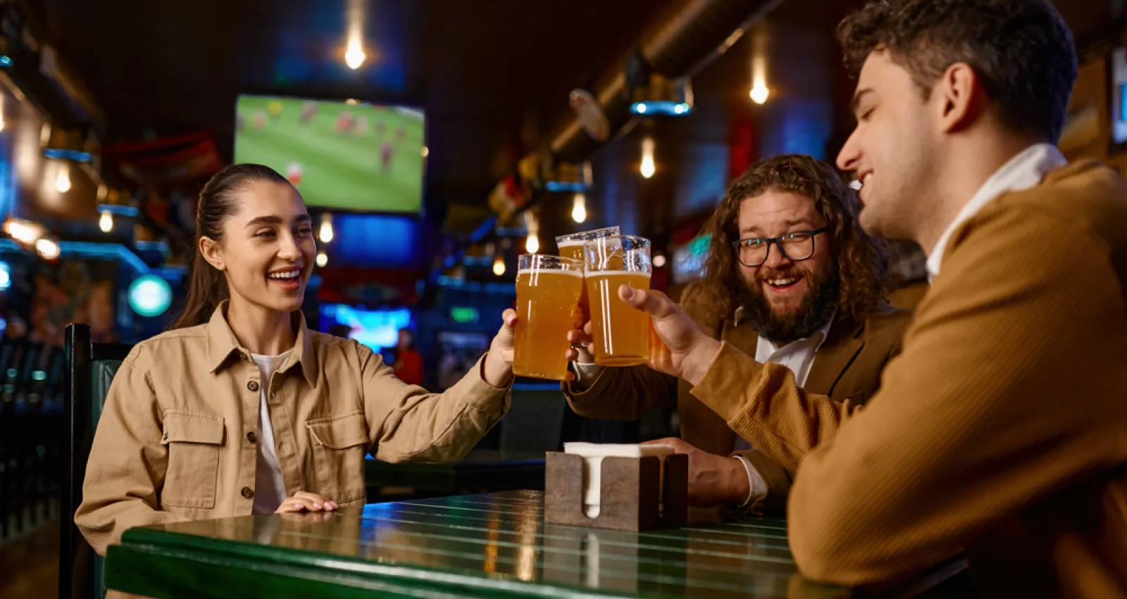 Amigos mirando un partido de futbol y tomando cerveza