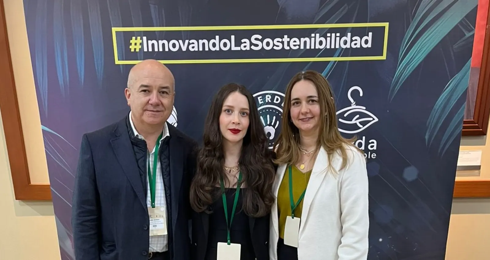 Foto de un hombre y dos mujeres a su lado mirando al lente