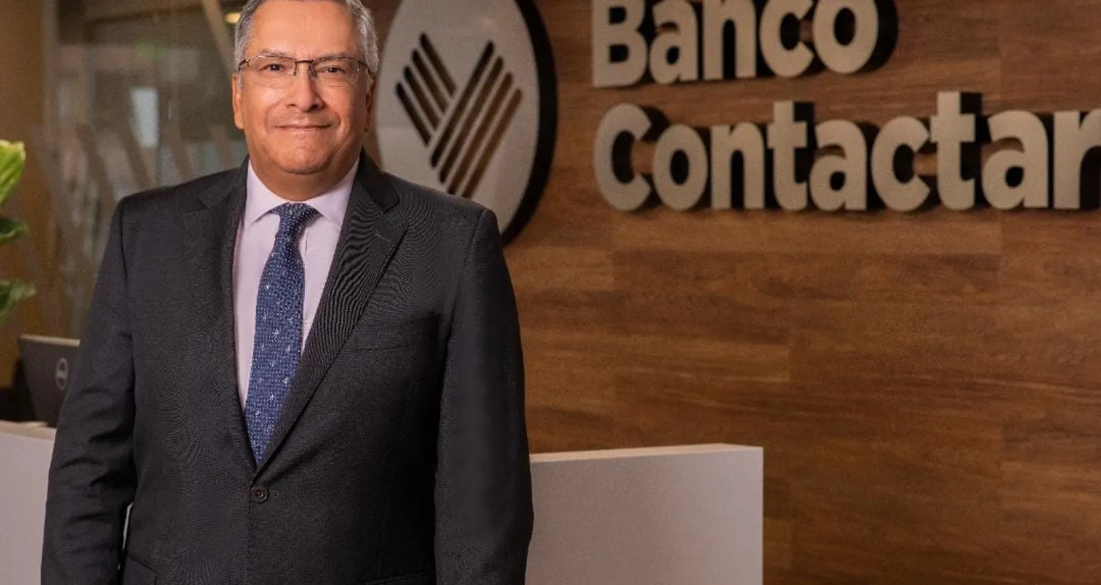 foto de un ejecutivo con corbata con un fondo que dice banco contactar