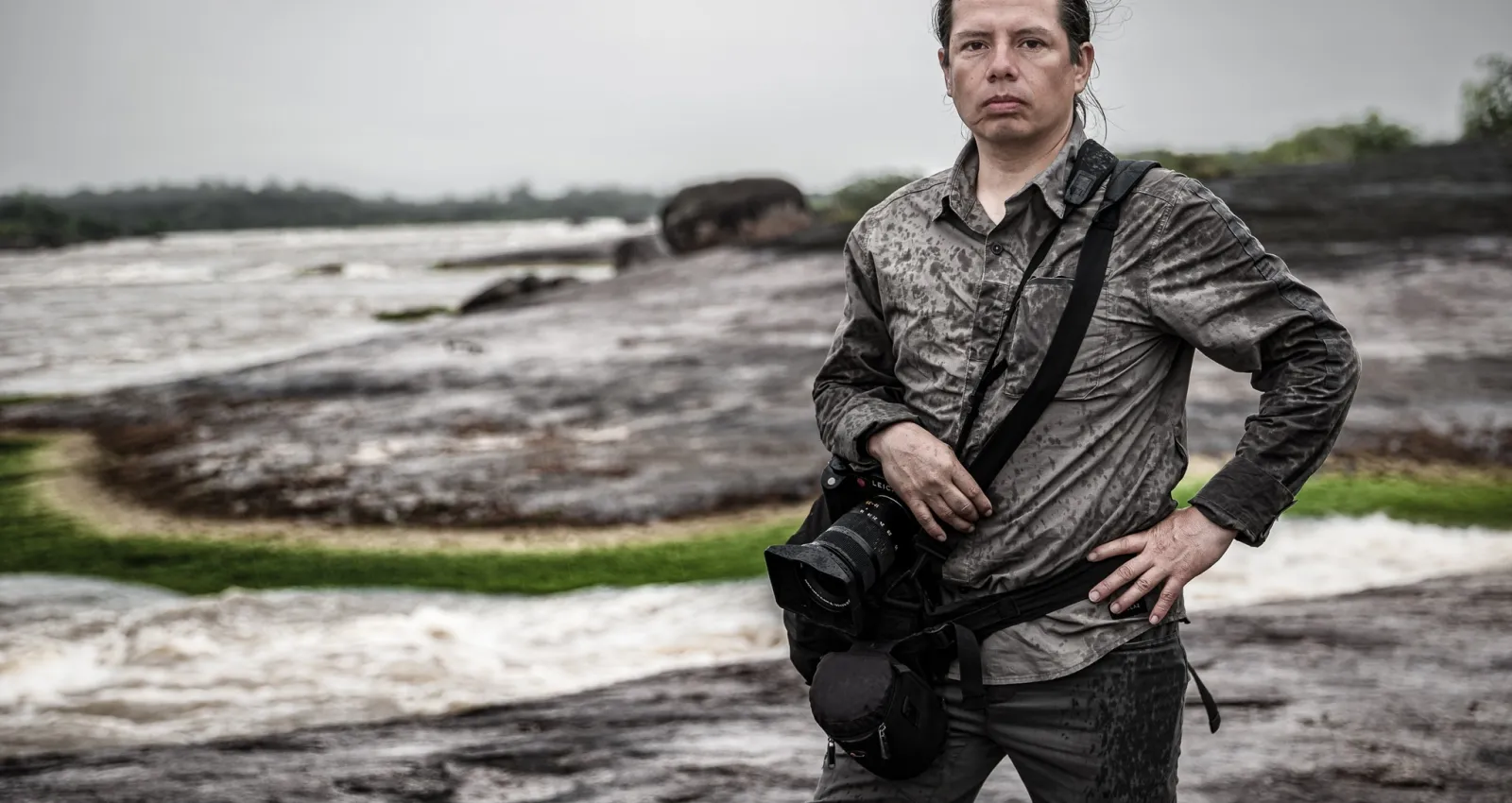 Fotografía de una persona posando con un paisaje oscuro
