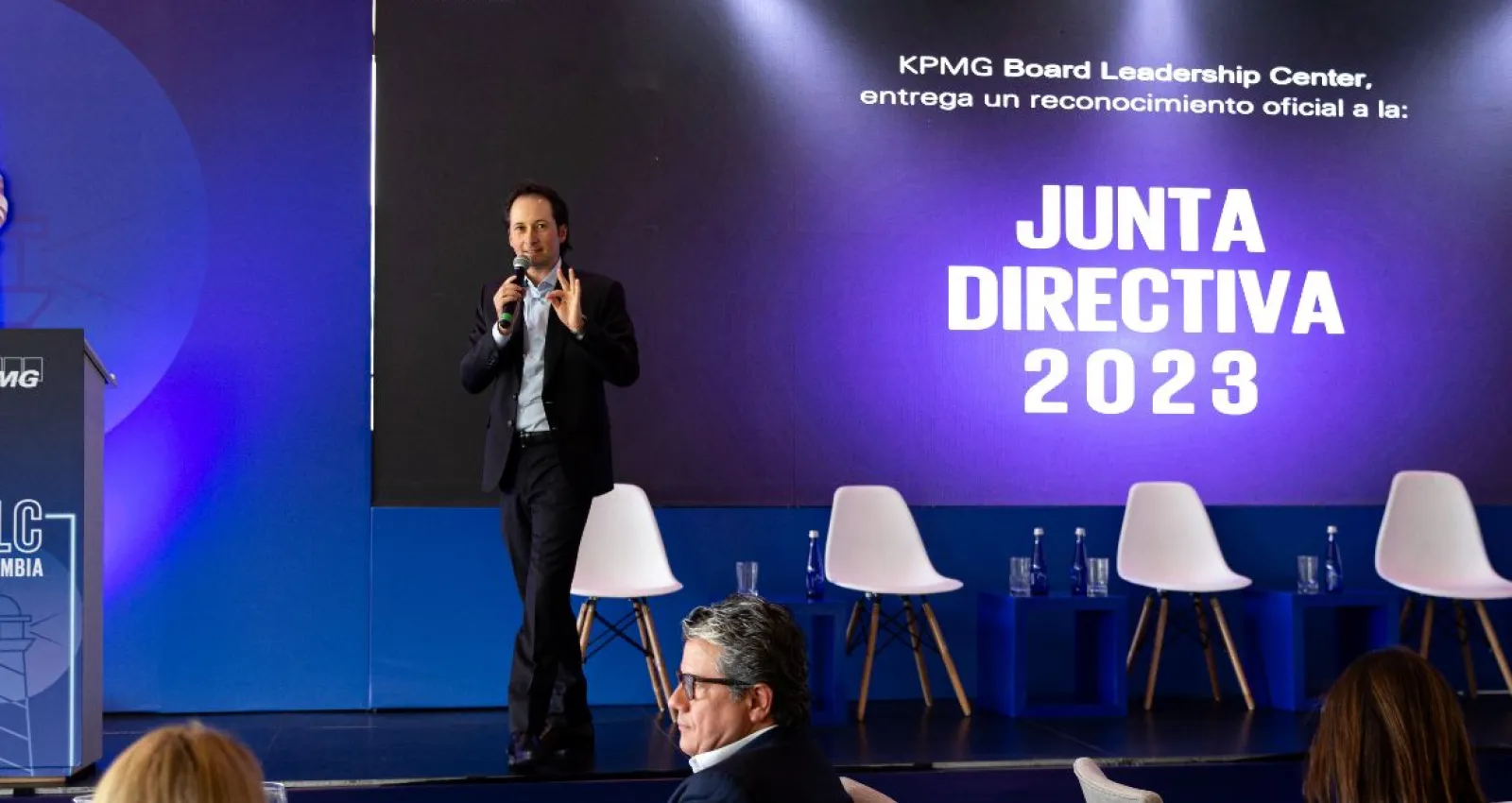 Foto de una persona presentando un tema a varios conferencistas