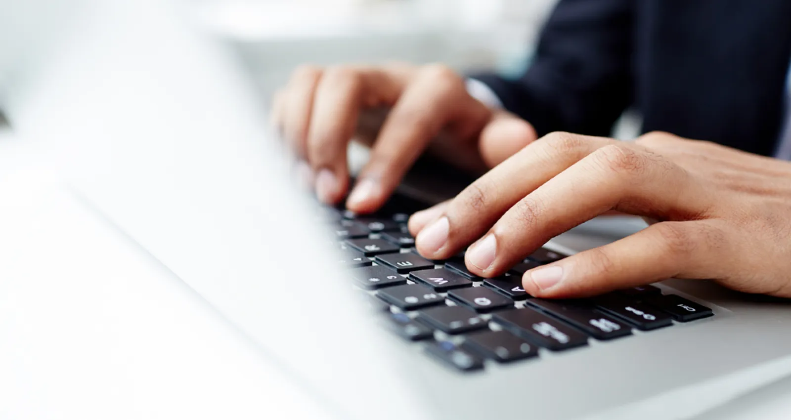 Imagen de una persona tecleando en un computador portatil