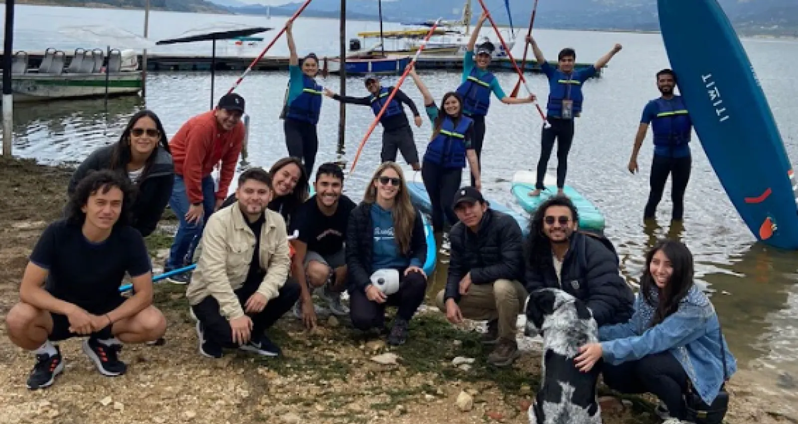 Foto devarias personas reunidas y mirando a la cámara con un lago de fondo