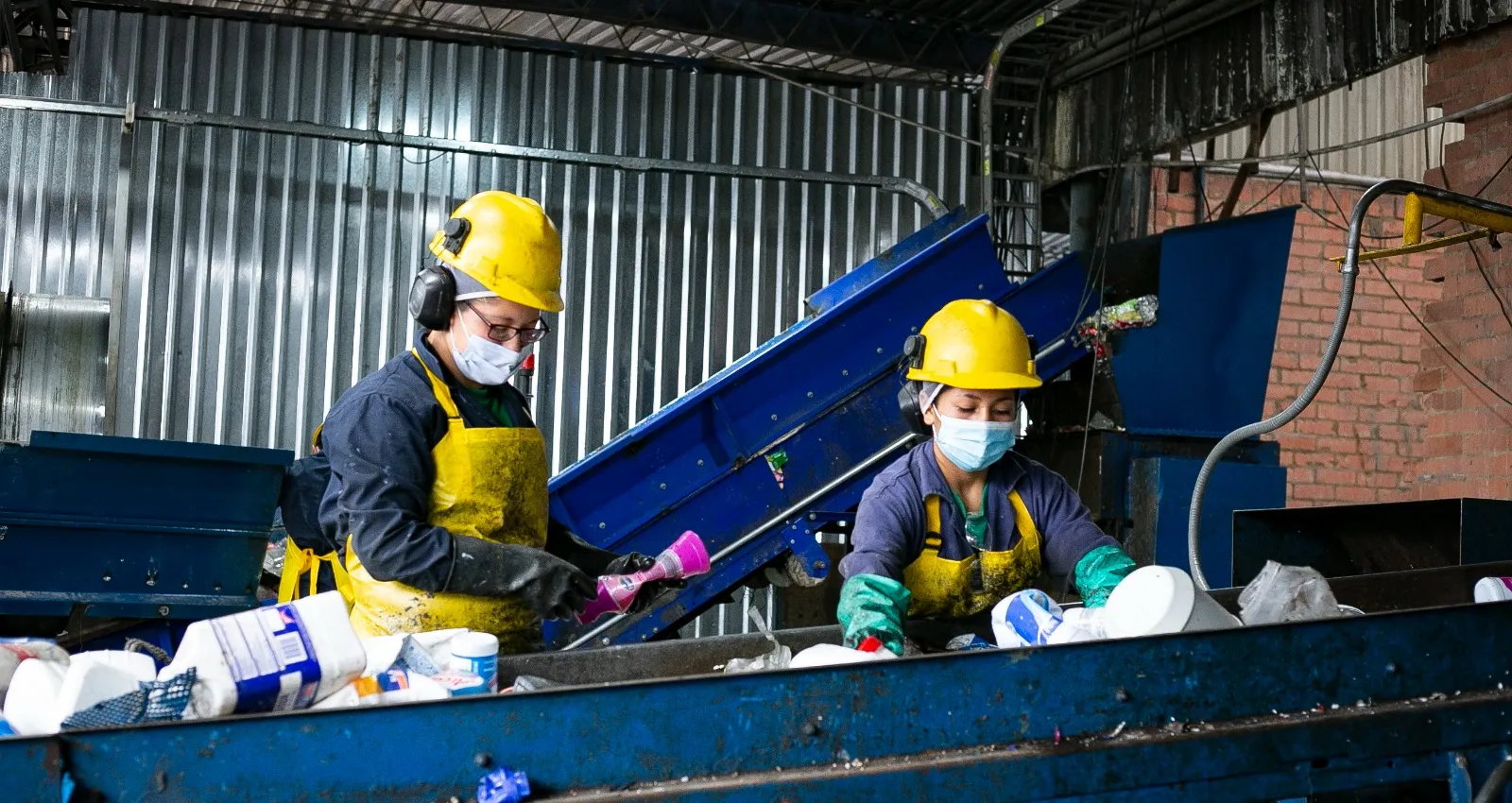 Representación de dos trabajadoras reciclando en una fábrica 