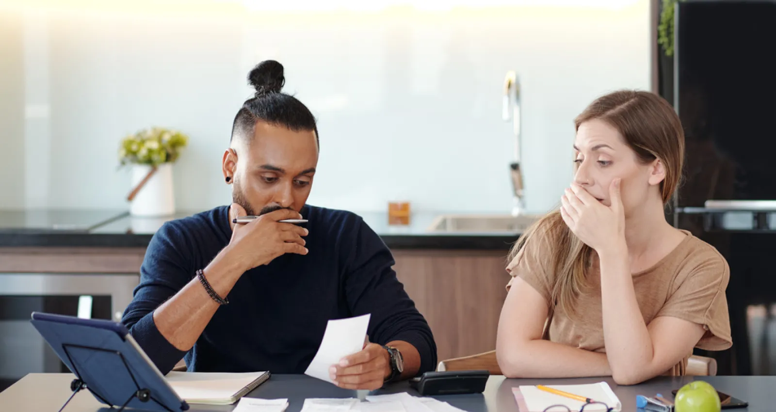 Dos personas sentadas en una mesa mirando una factura