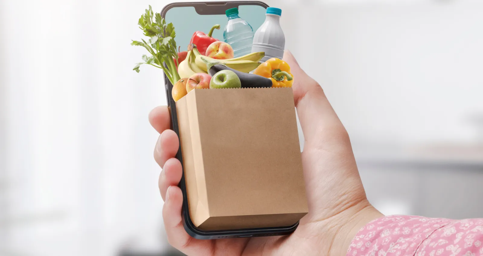 mano con celular y bolsas de comprar
