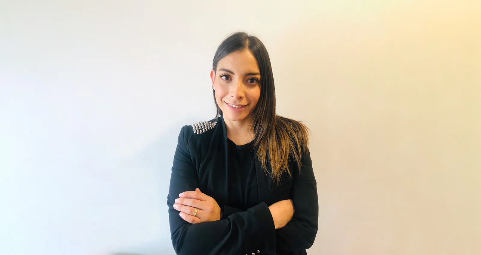 Foto de una mujer con blazer negro mirando a la cámara
