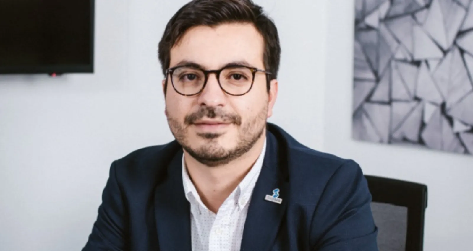 Okar Sarquis, foto de un hombre con traje y gafas mirando a la cámara
