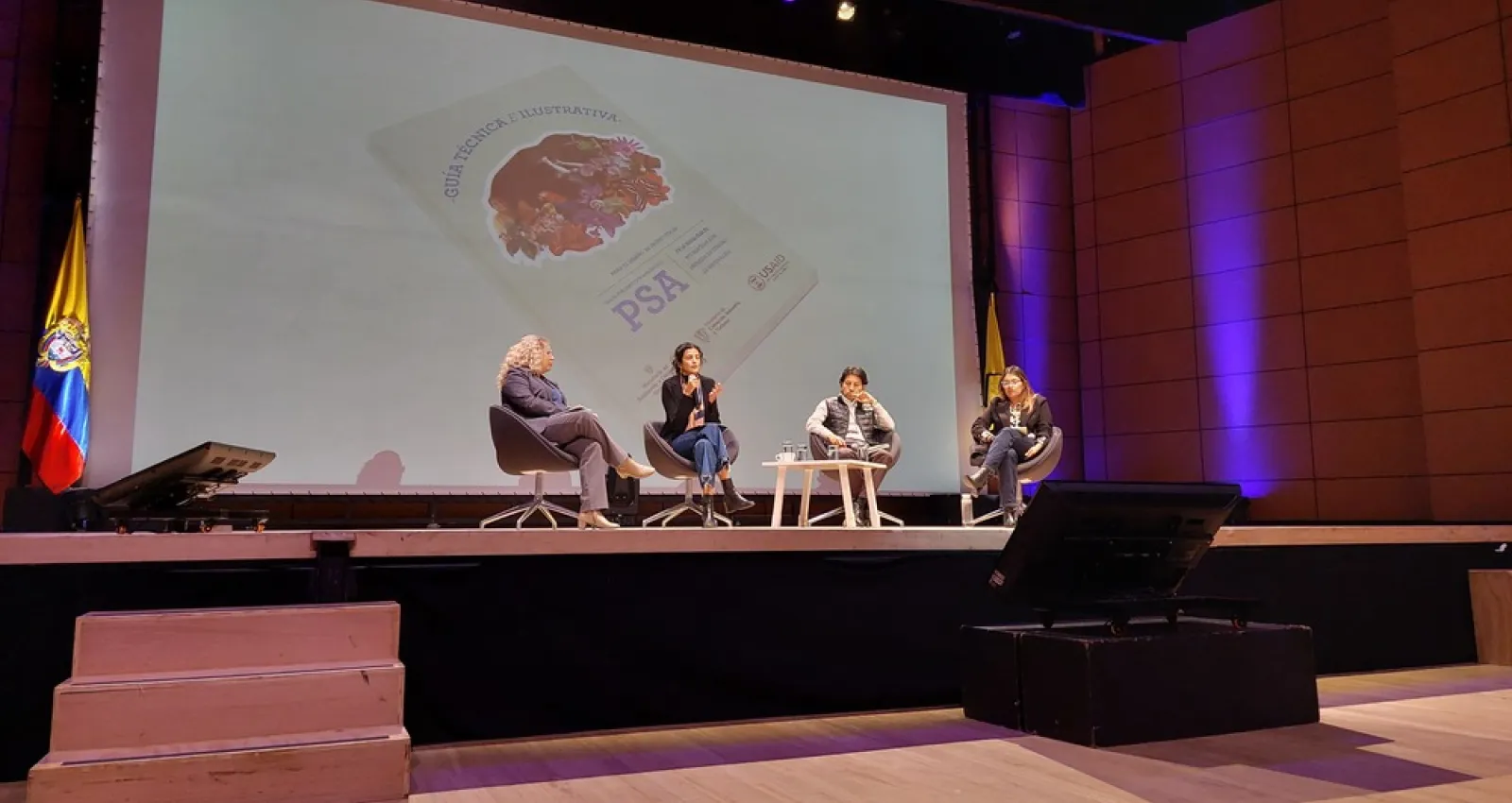 Foto de cuatro mujeres sentadas frente a un panel