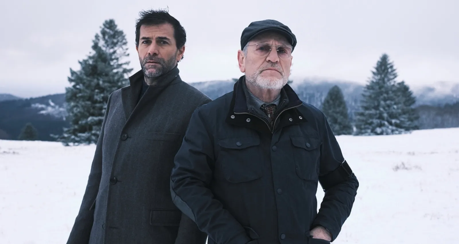 Foto de dos hombres con chaquetas y nieve de fondo
