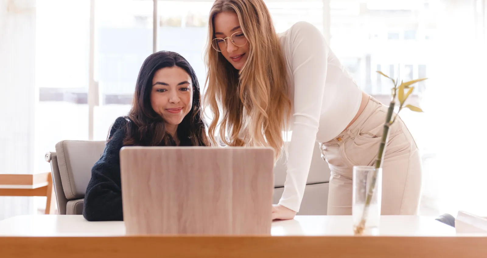 Foto de dos mujeres hablando con una computadora al frente