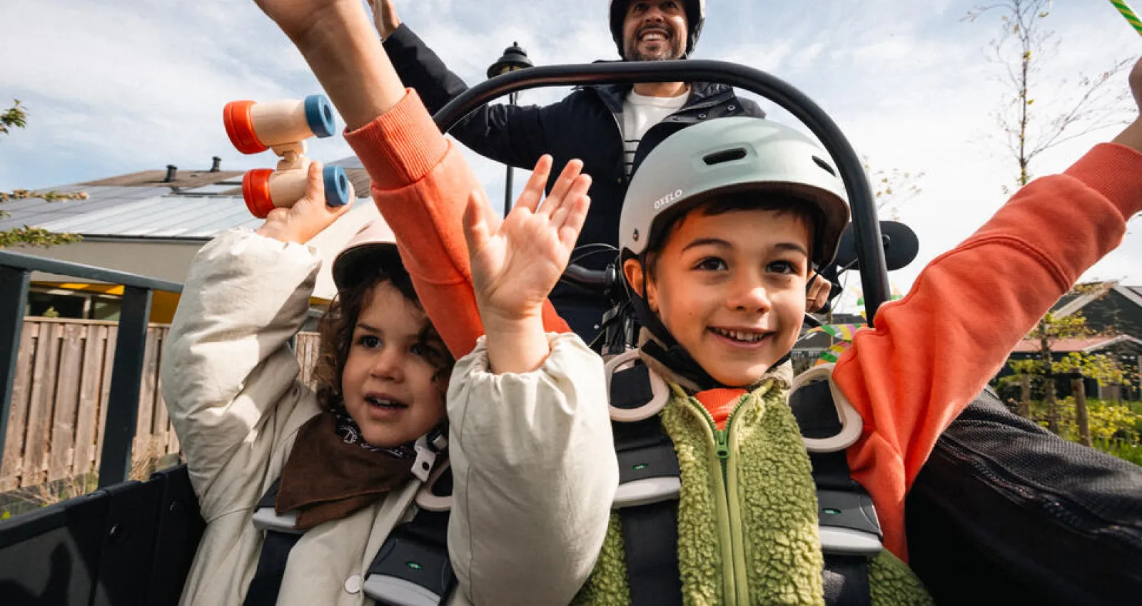 Foto de dos niños disfrutando en una montaña rusa, están alzando las manos
