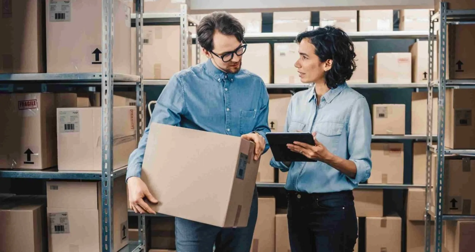 Foto de dos personas hablando con cajas de fondo
