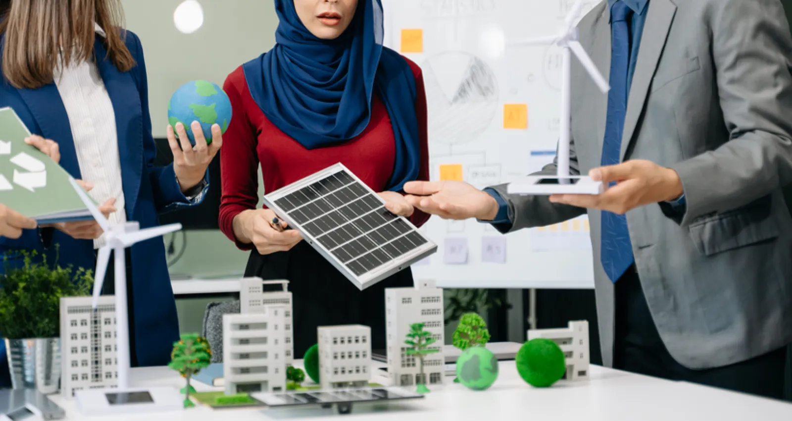 Foto de ejecutivos mirando un panel solar con un proyecto en la mesa