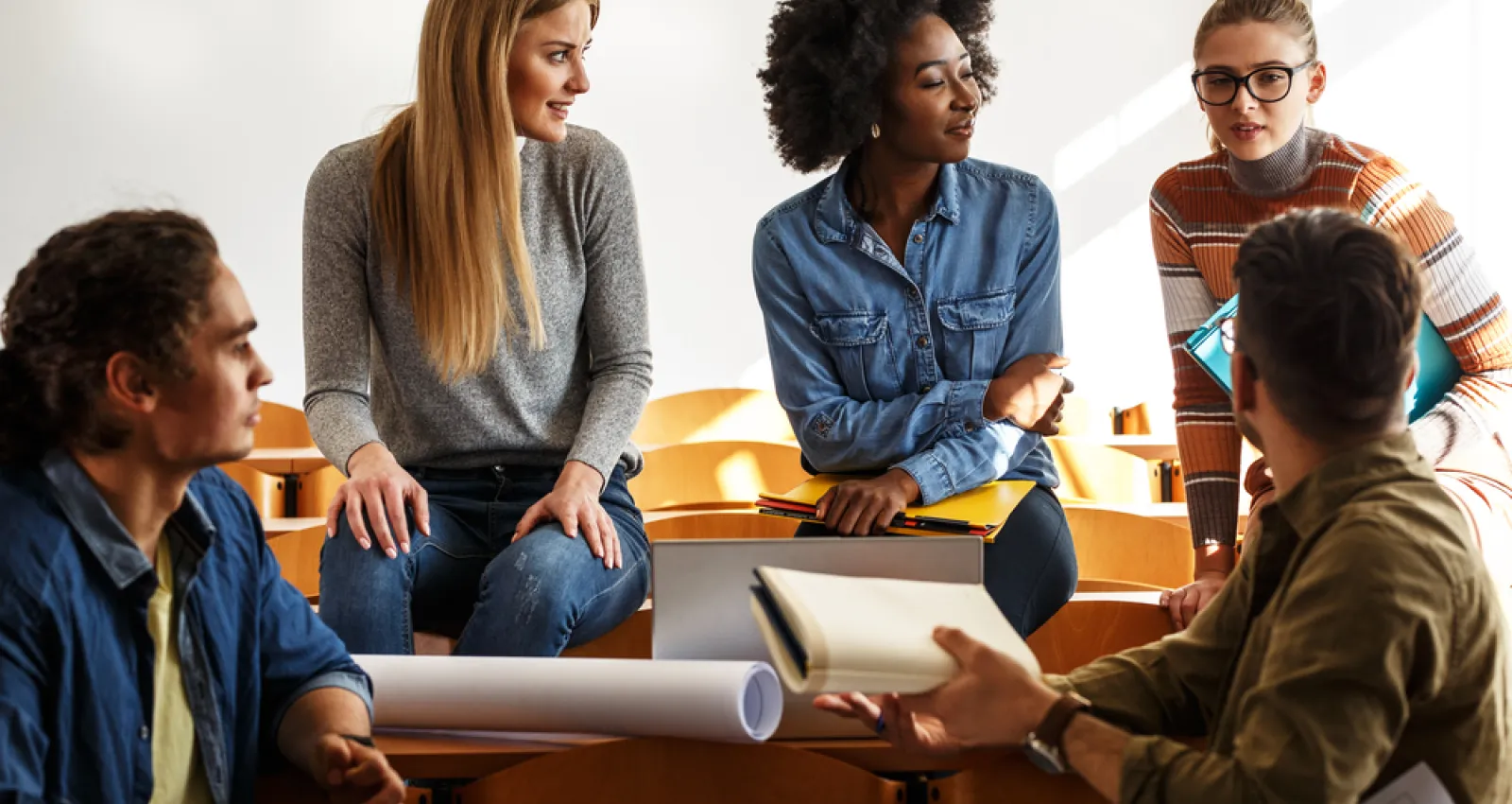 Foto de estudiantes hablando en un salon de clases 