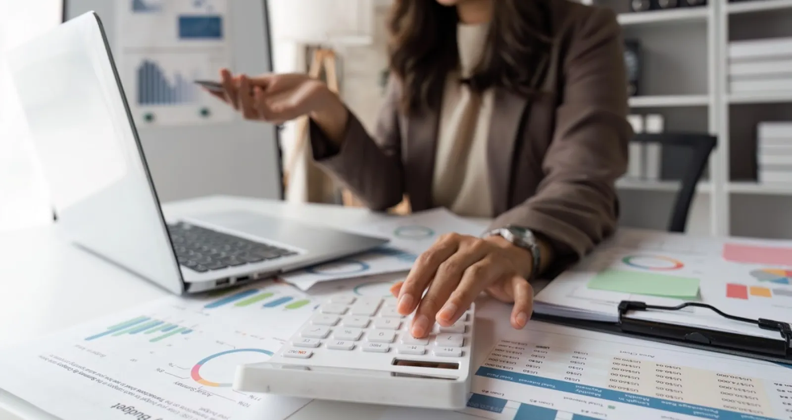 Foto de la mano de una mujer cuadrando las finanzas de una compañía