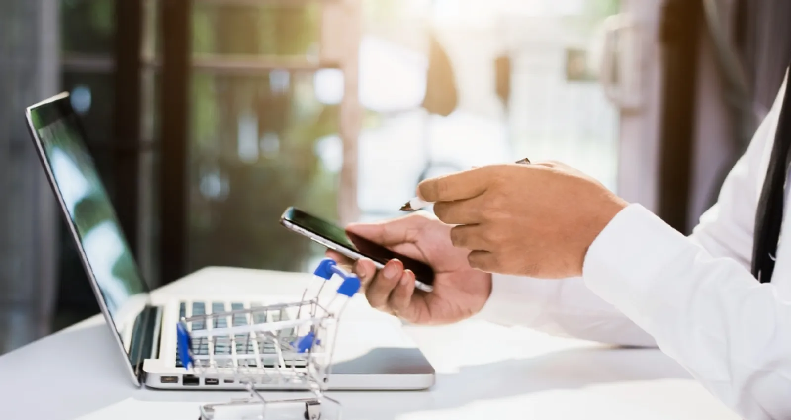Foto de las manos de una persona comprando en línea por medio de un celular