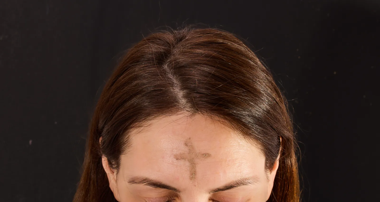 Foto de mujer con una cruz en la frente