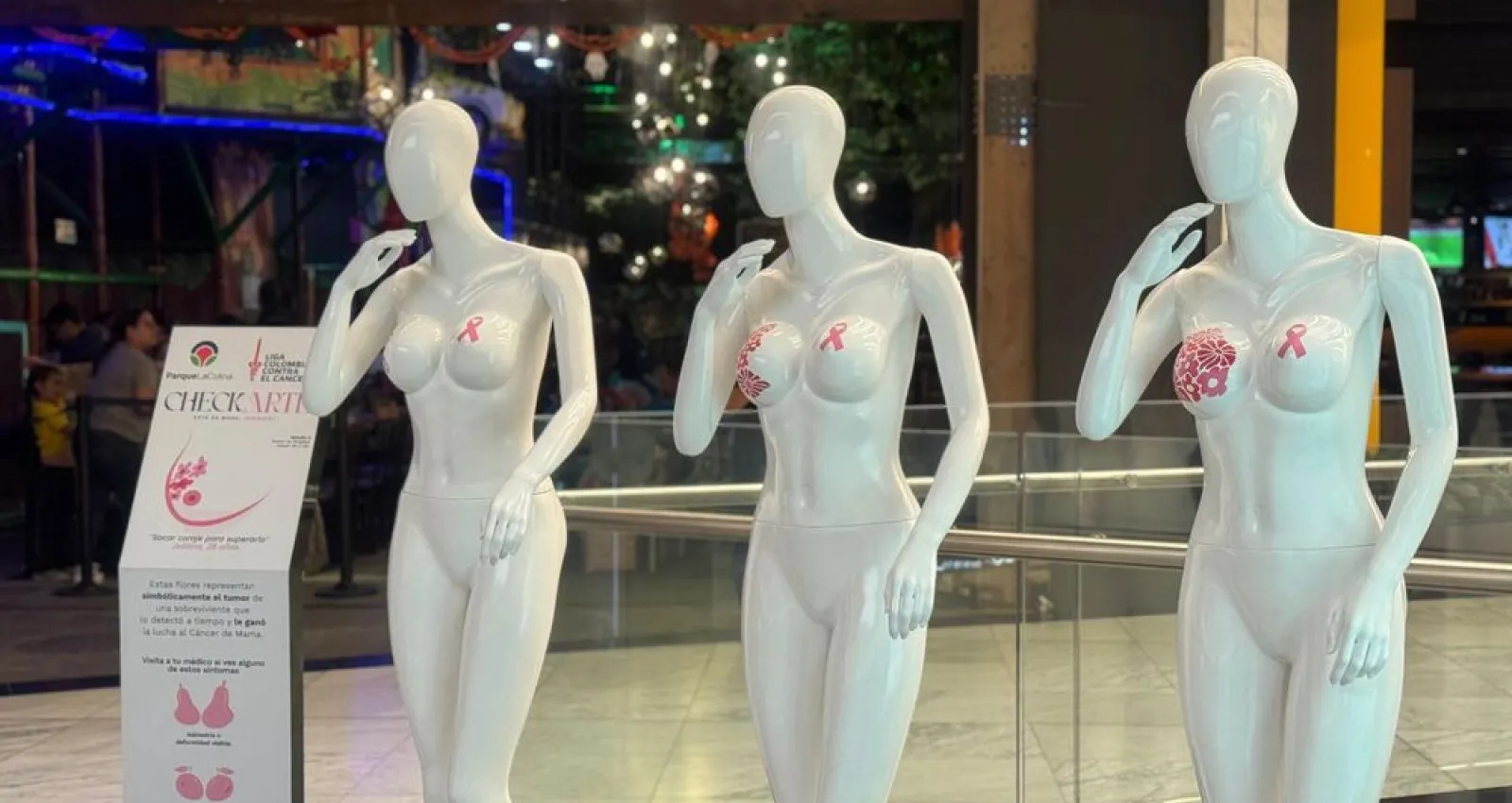 Foto de tres maniquies blancos con figuras rosadas