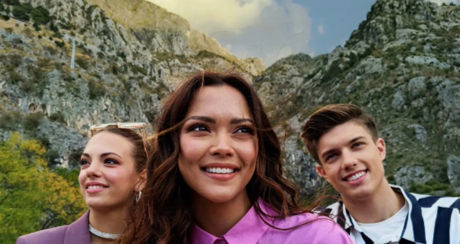 Foto de tres personas mirando a la cámara con una montaña de espaldas