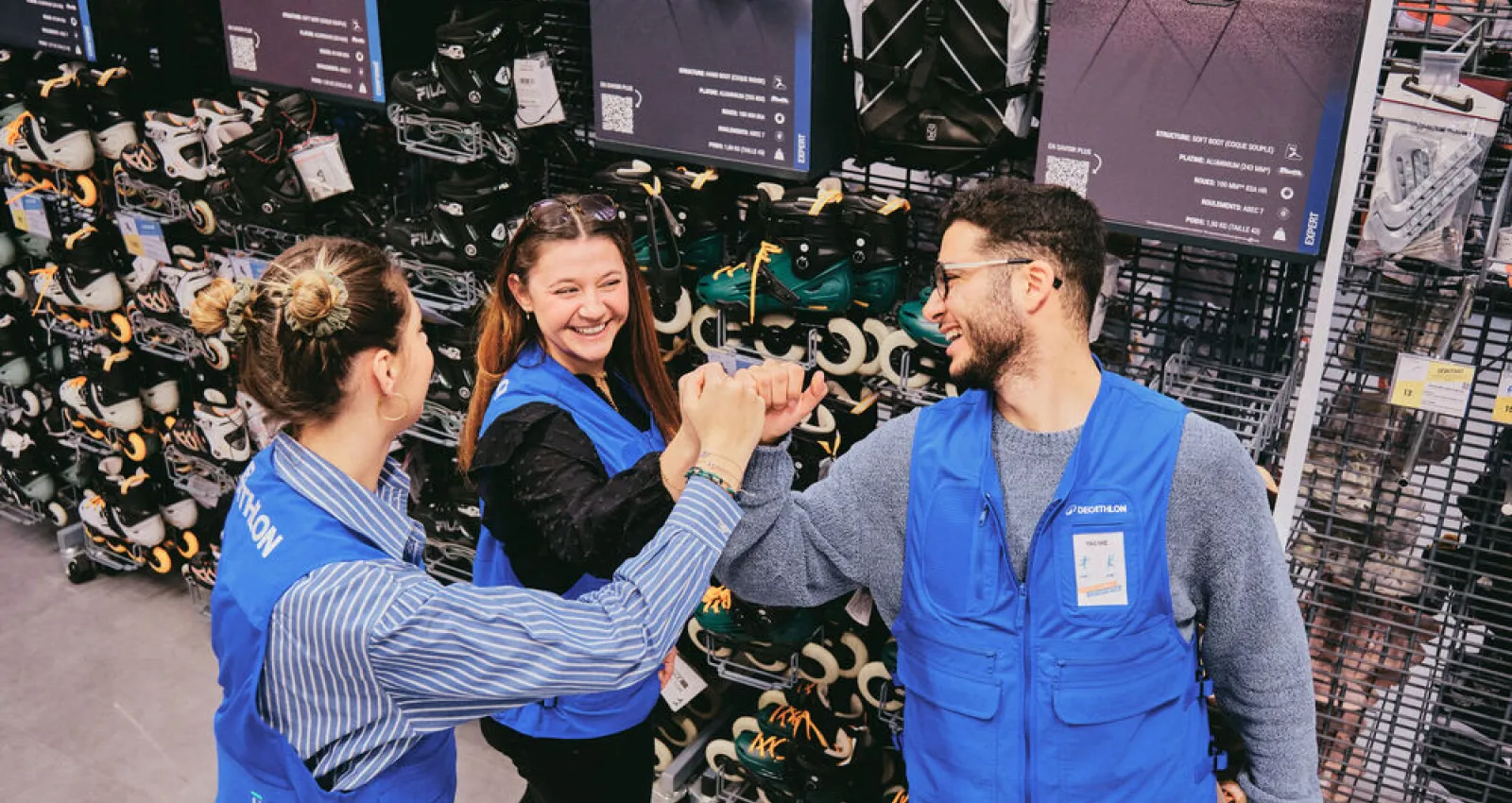 Foto de tres trabajadores de decathlon juntando sus manos