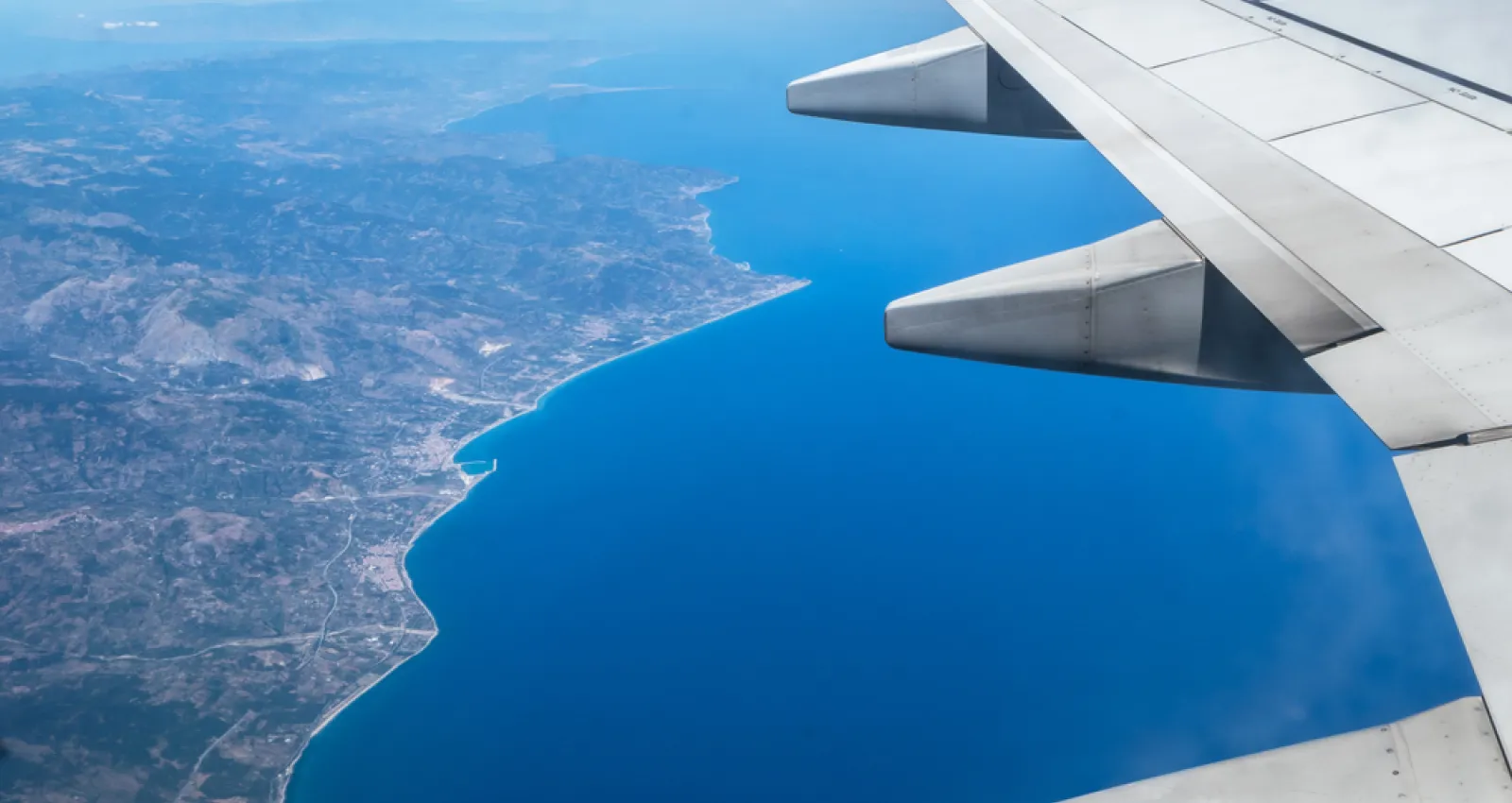Foto de un ala de un avión y debajo la tierra y el mar