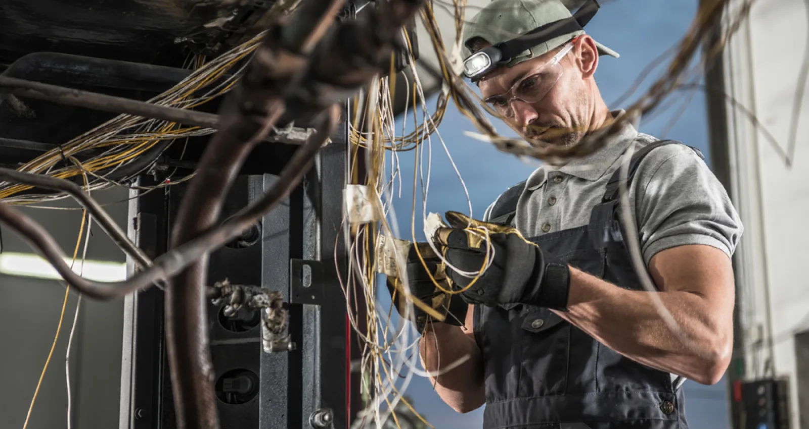 Foto de un electricista trabando con cables en sus manos