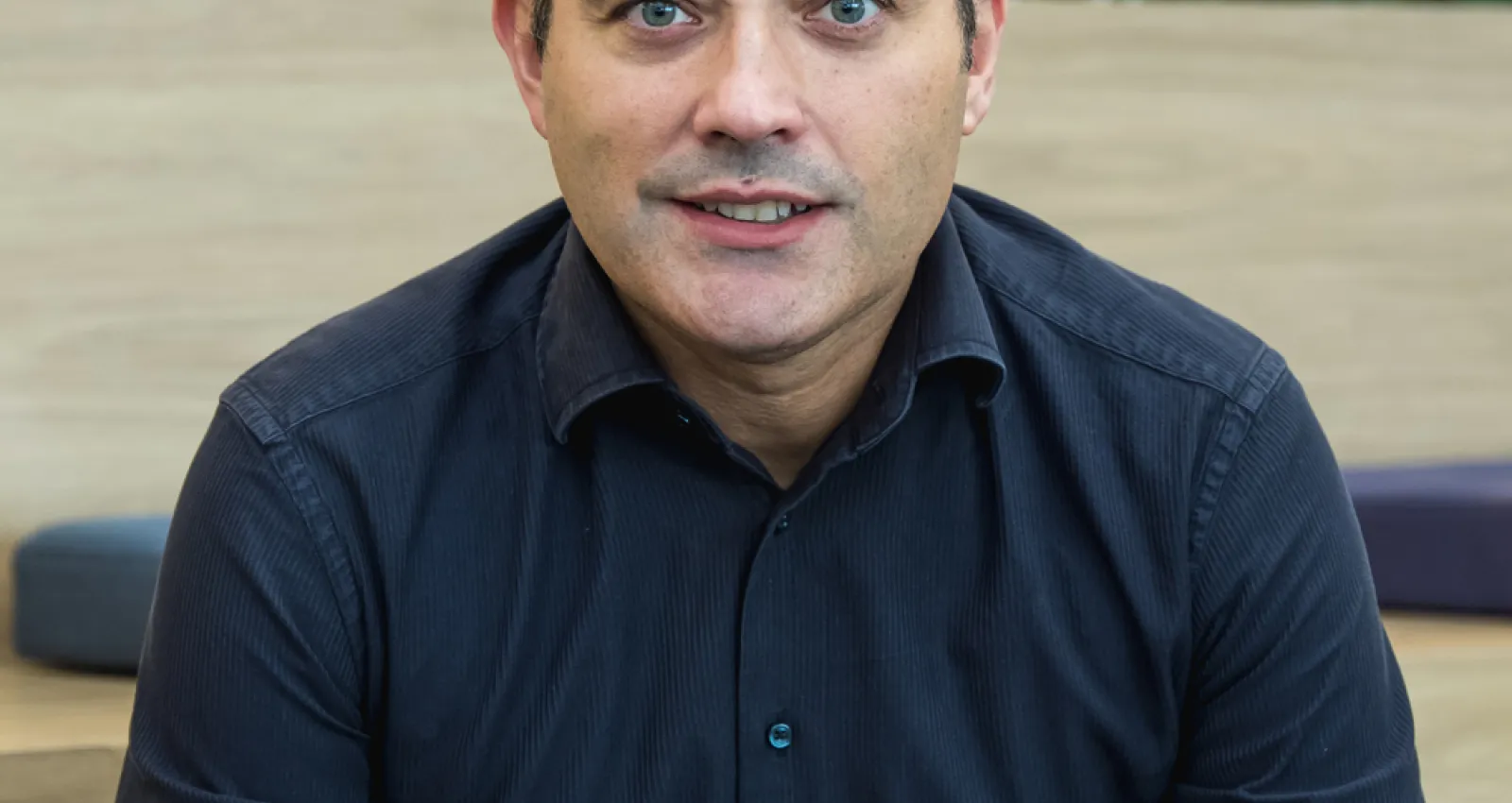 Foto de un hombre con camiseta azul mirando a la cámara