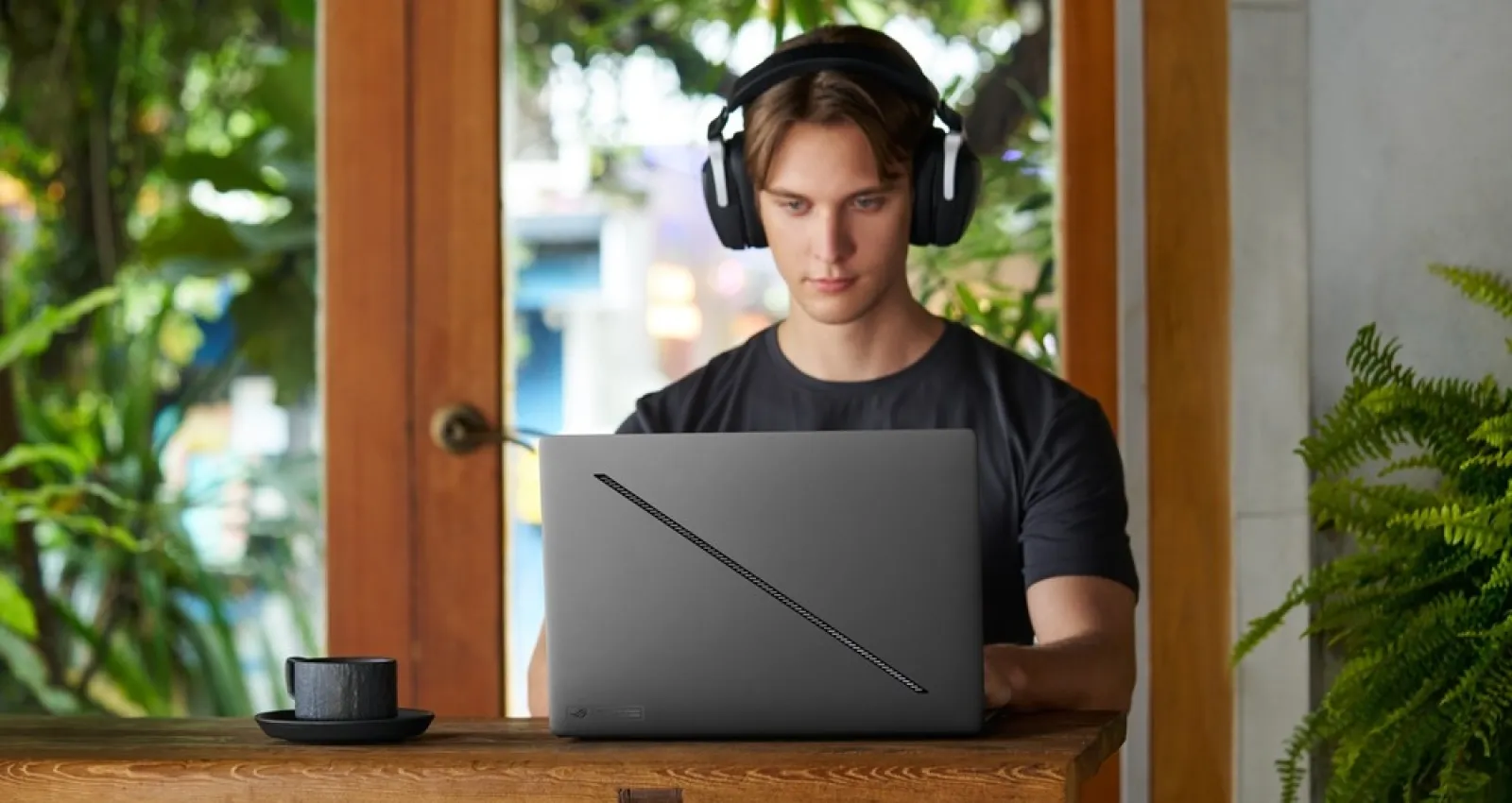 Foto de un hombre jóven y serio mirando un computador de Asus