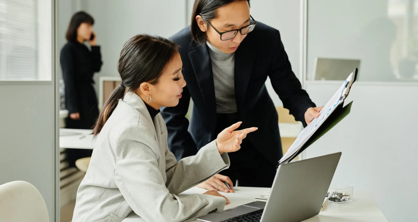 Foto de un hombre y una mujer trabajando frente a un computador