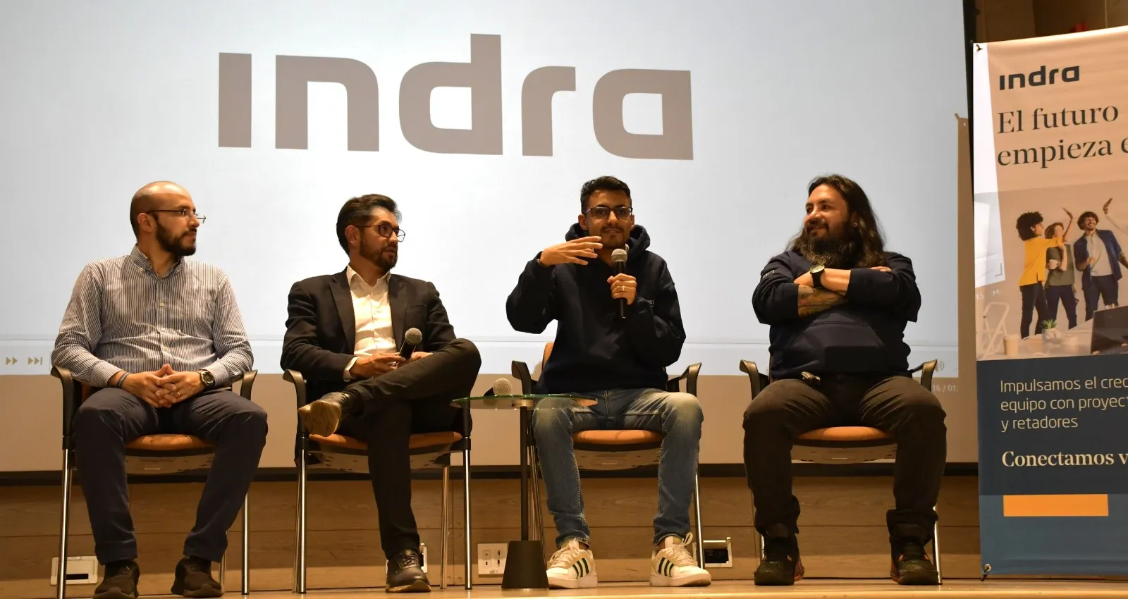 Foto de un panel con cuatro personas sentadas