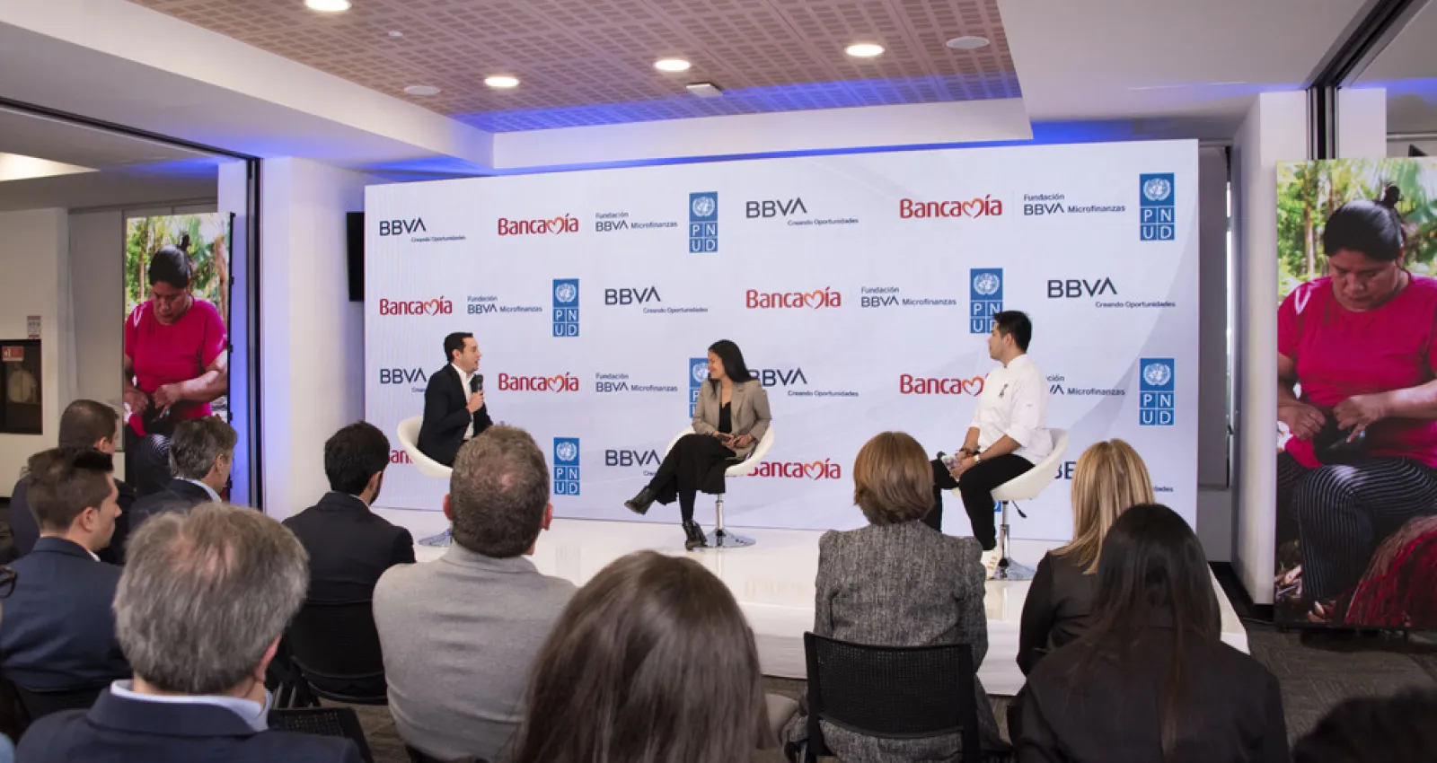Foto de un panel con tres personas sentadas conversando Bancamía