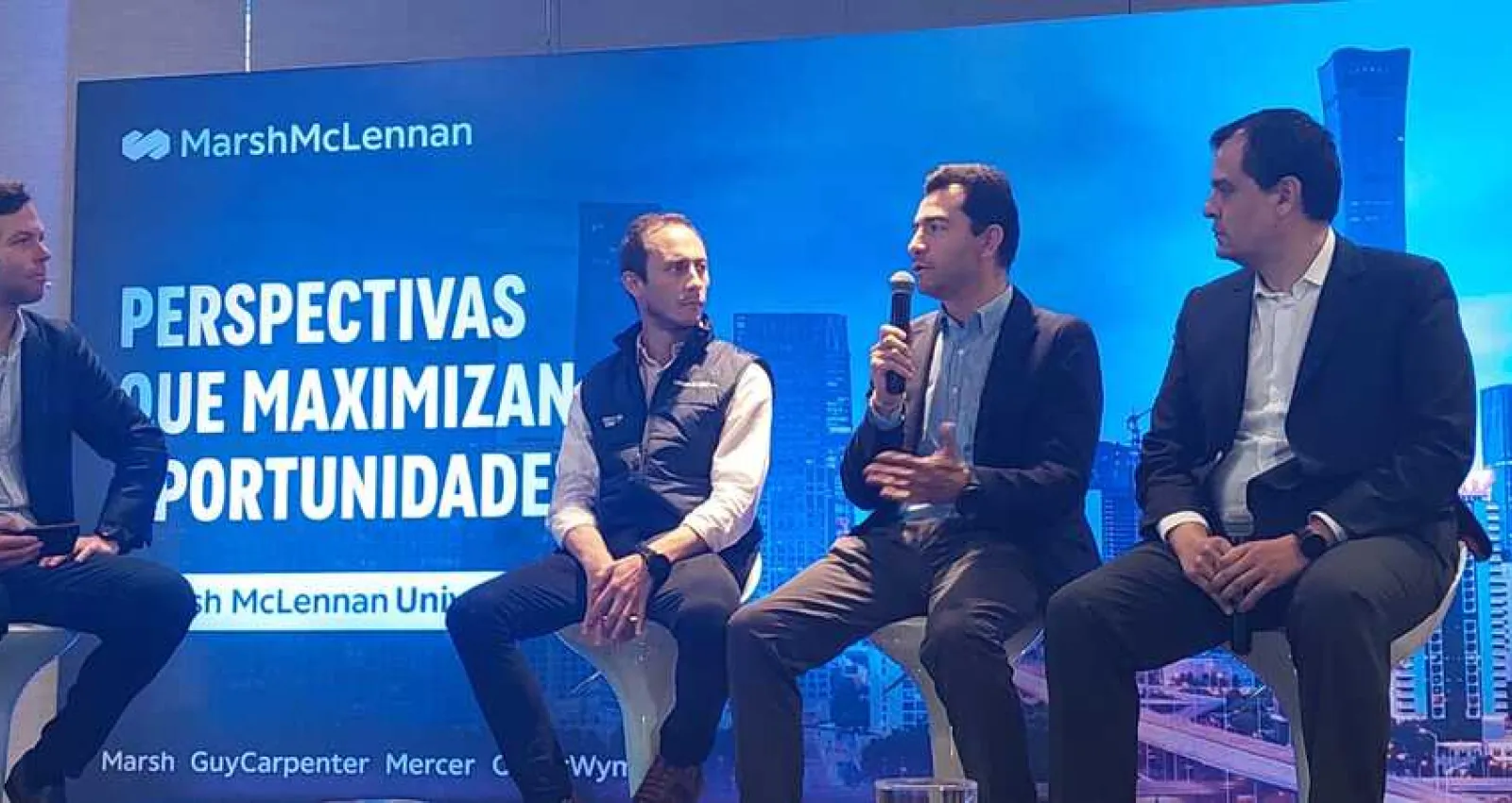 Foto de un panel de cuatro hombres con un fondo purpura