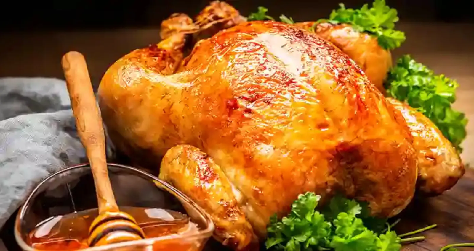 Foto de un pollo junto a un frasco de miel al costado