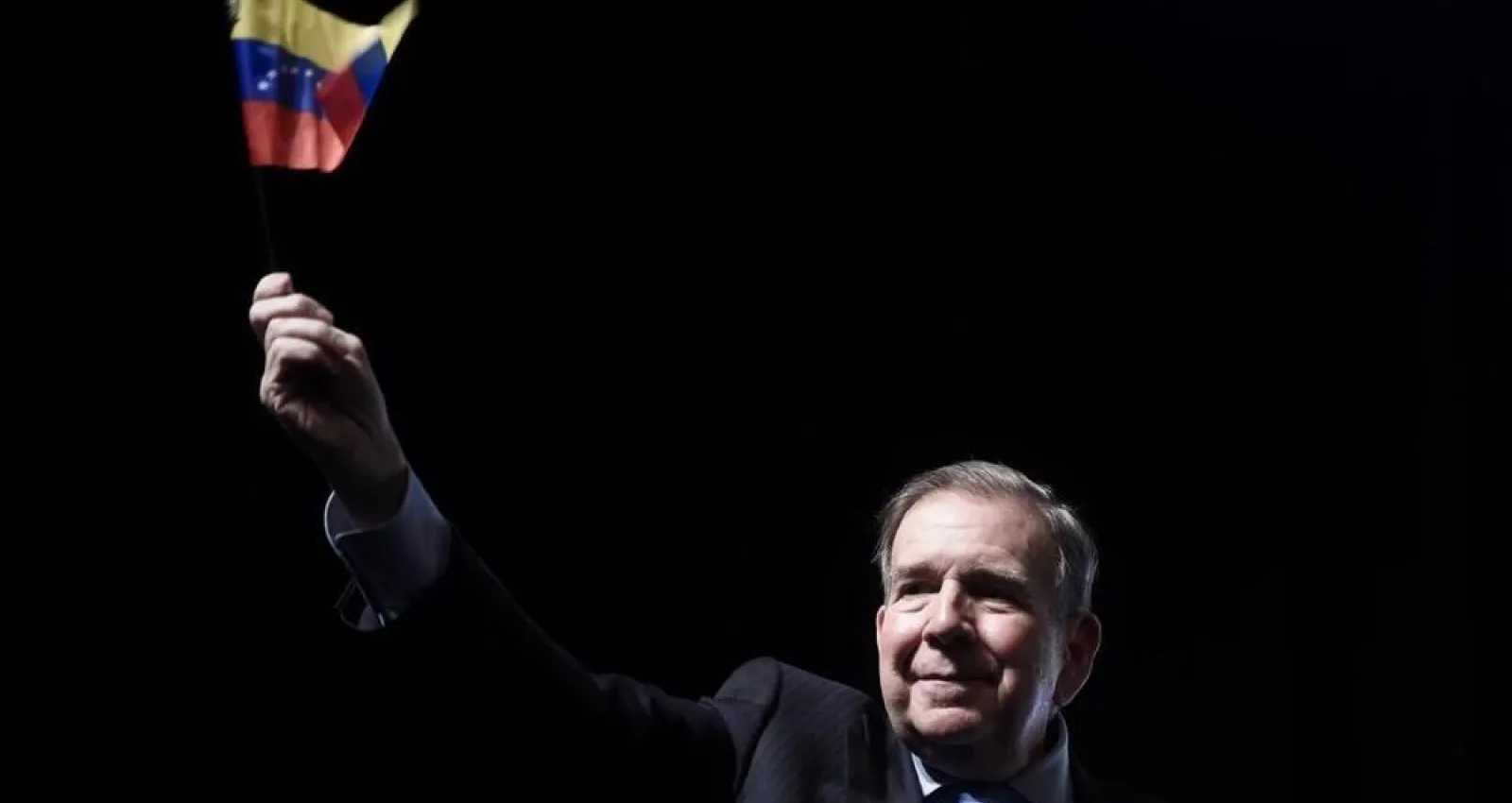 Foto de un señor con la bandera de venezuela en la mano derecha