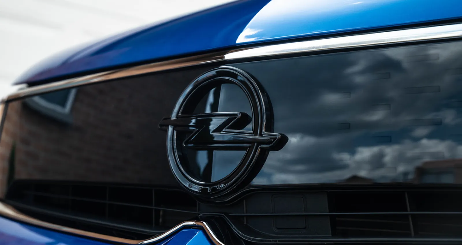 Foto de una camioneta azul con el logo de Opel