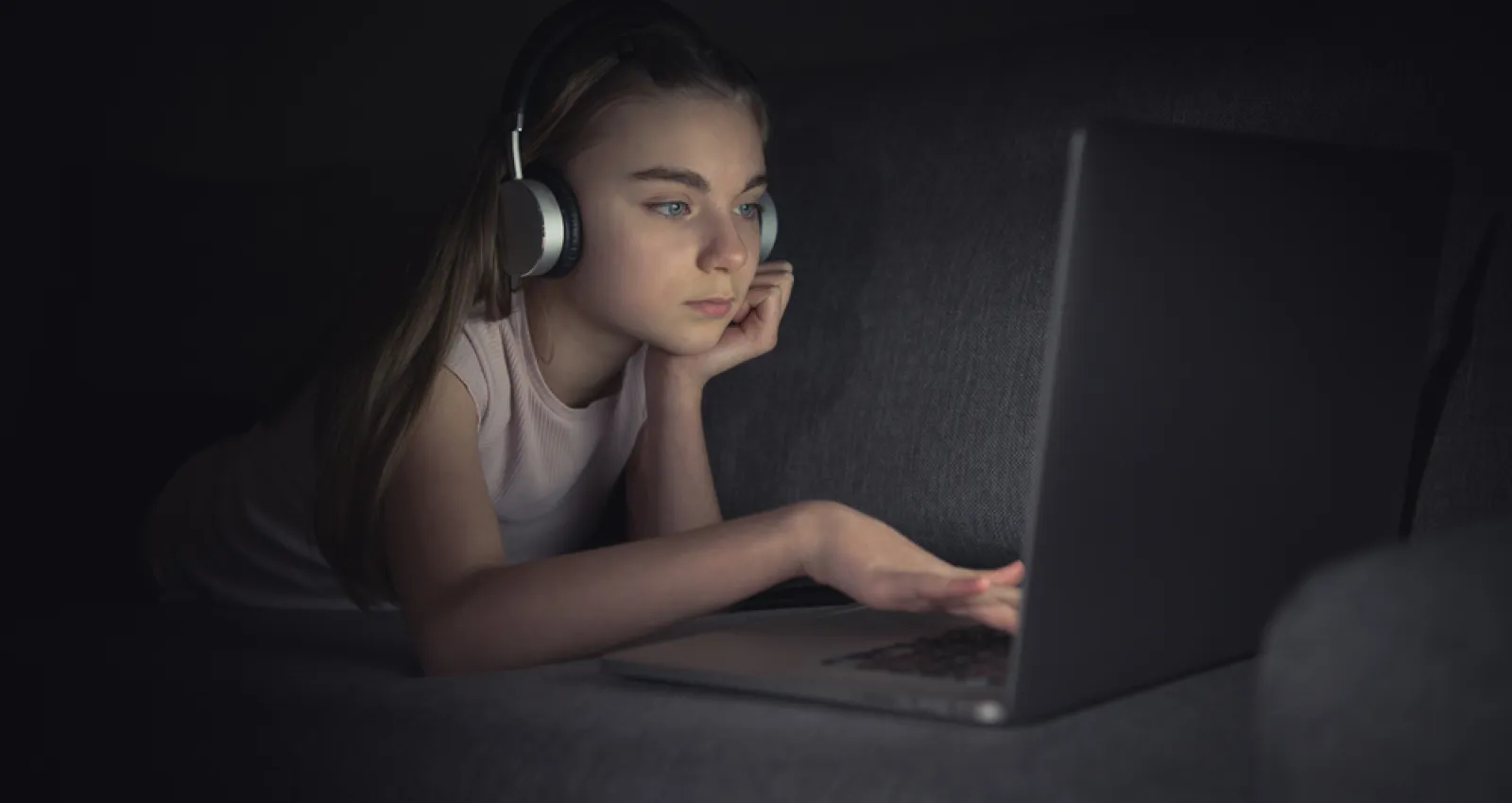 Foto de una chica mirando la computadora en la noche