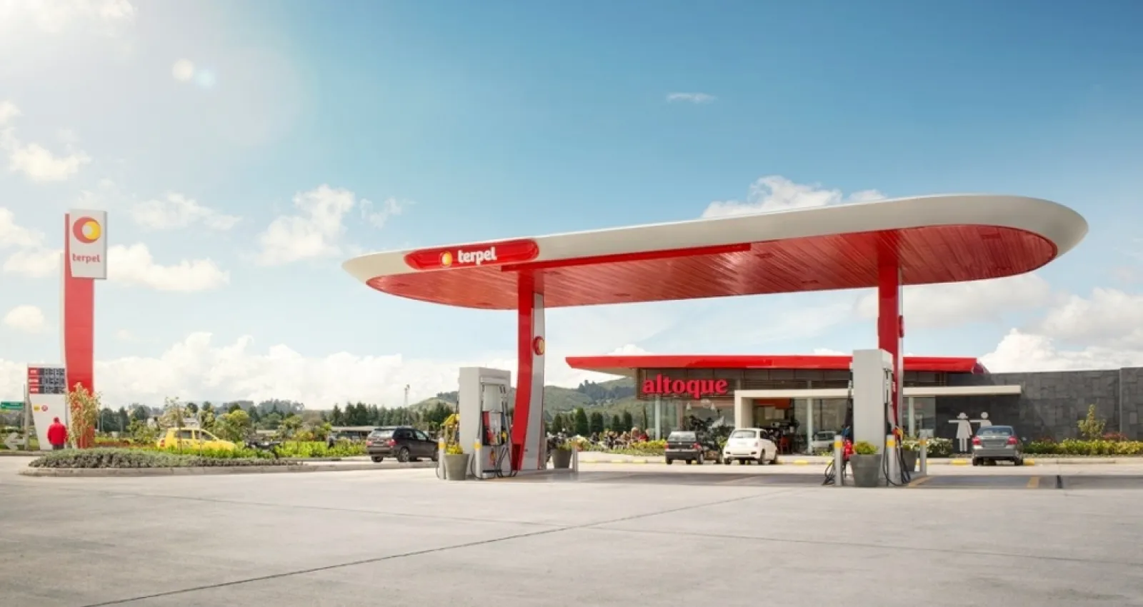 Foto de una estación de gasolina con un día soleado de fondo