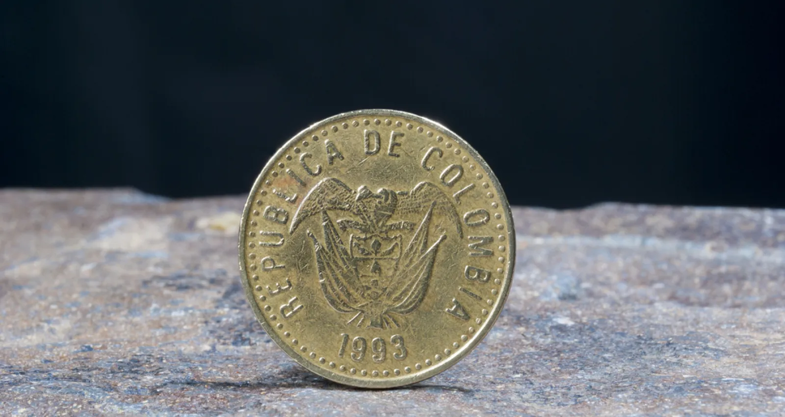 Foto de una imagen de 100 pesos de un lado con un fondo negro