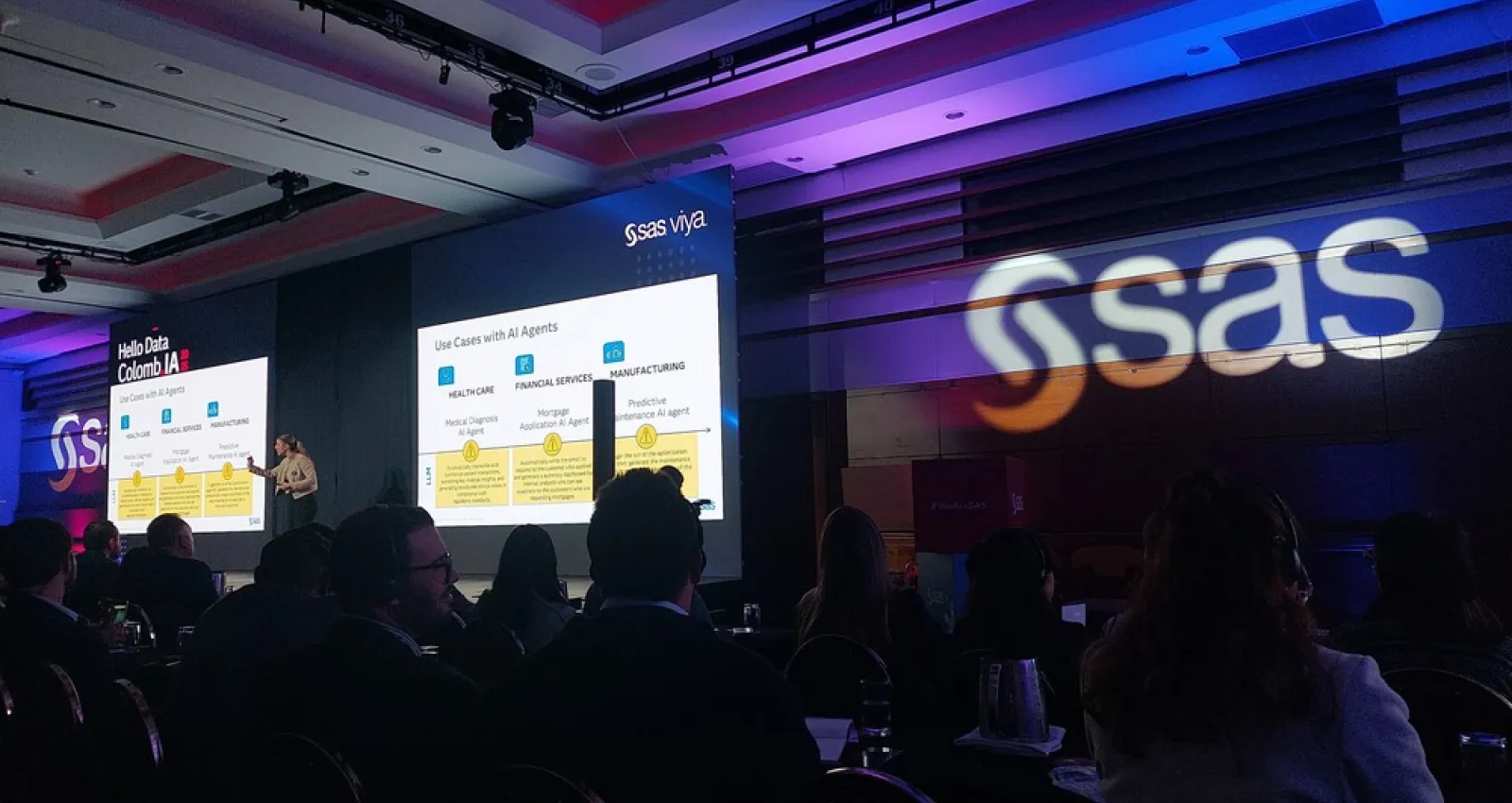 Foto de una mujer exponiendo un tema con un logo que dice SAS