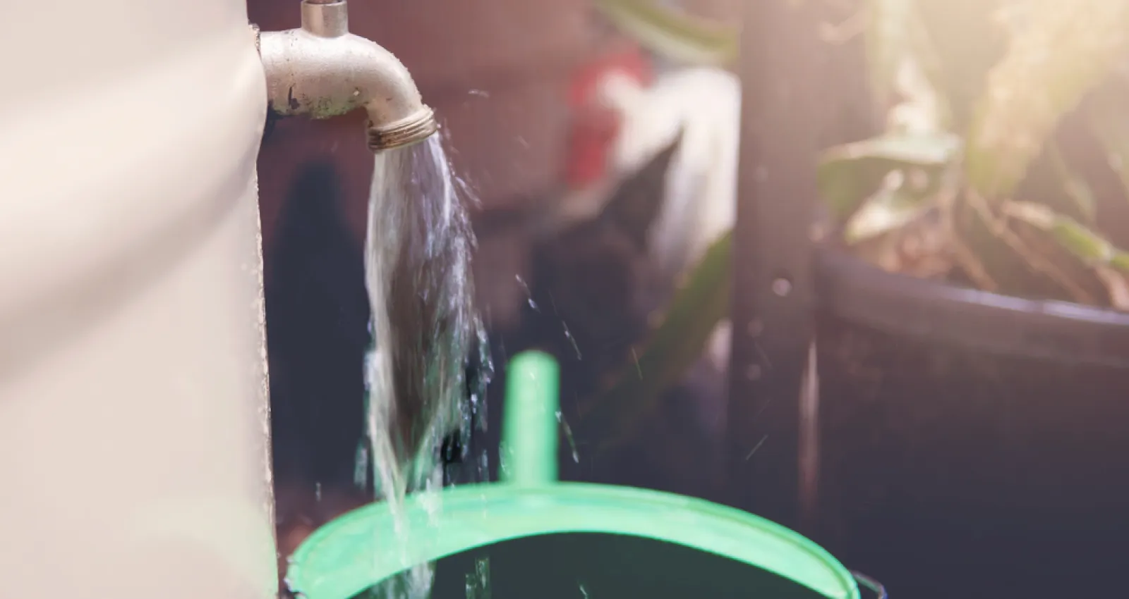 Foto de una llave de agua distribuyendo agua a un balde