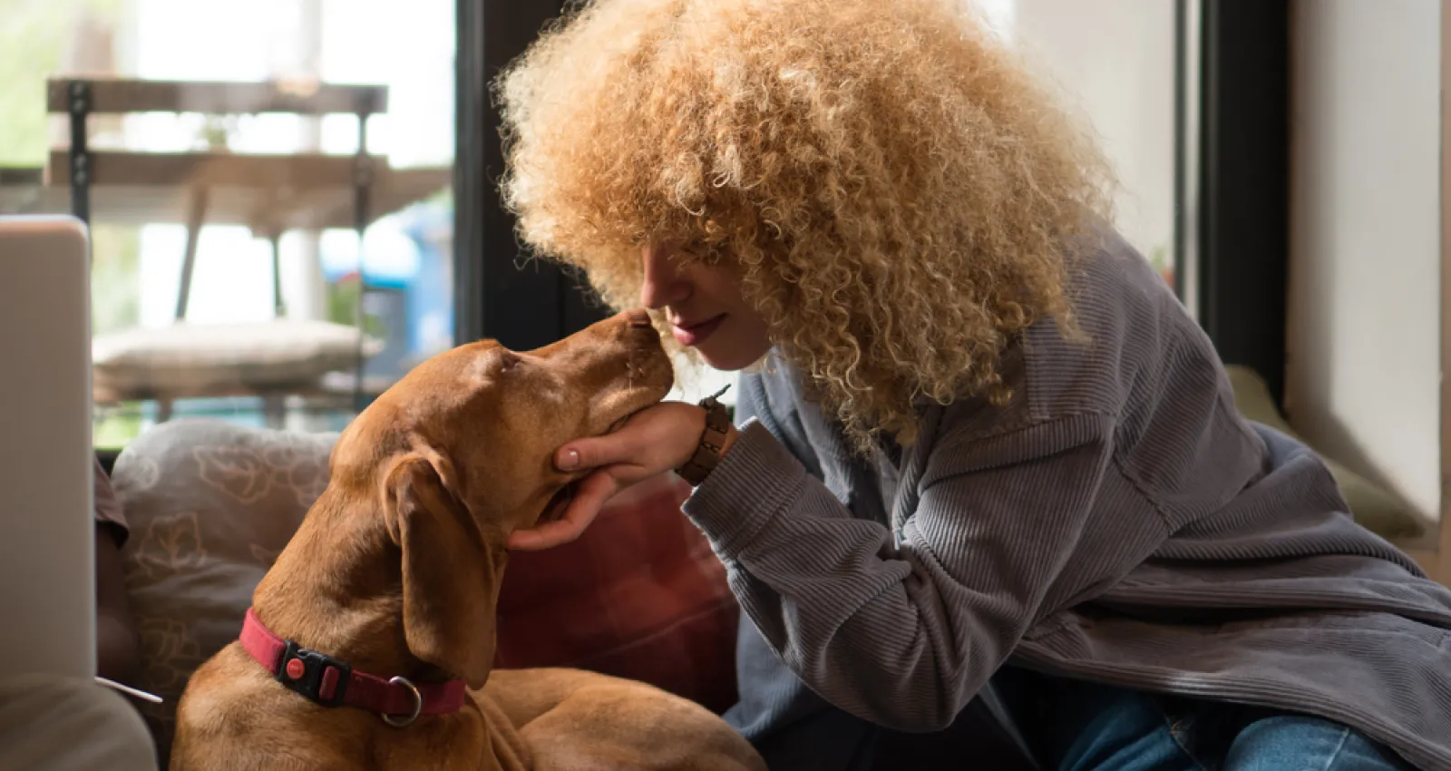 Foto de una mujer acariciando un perro