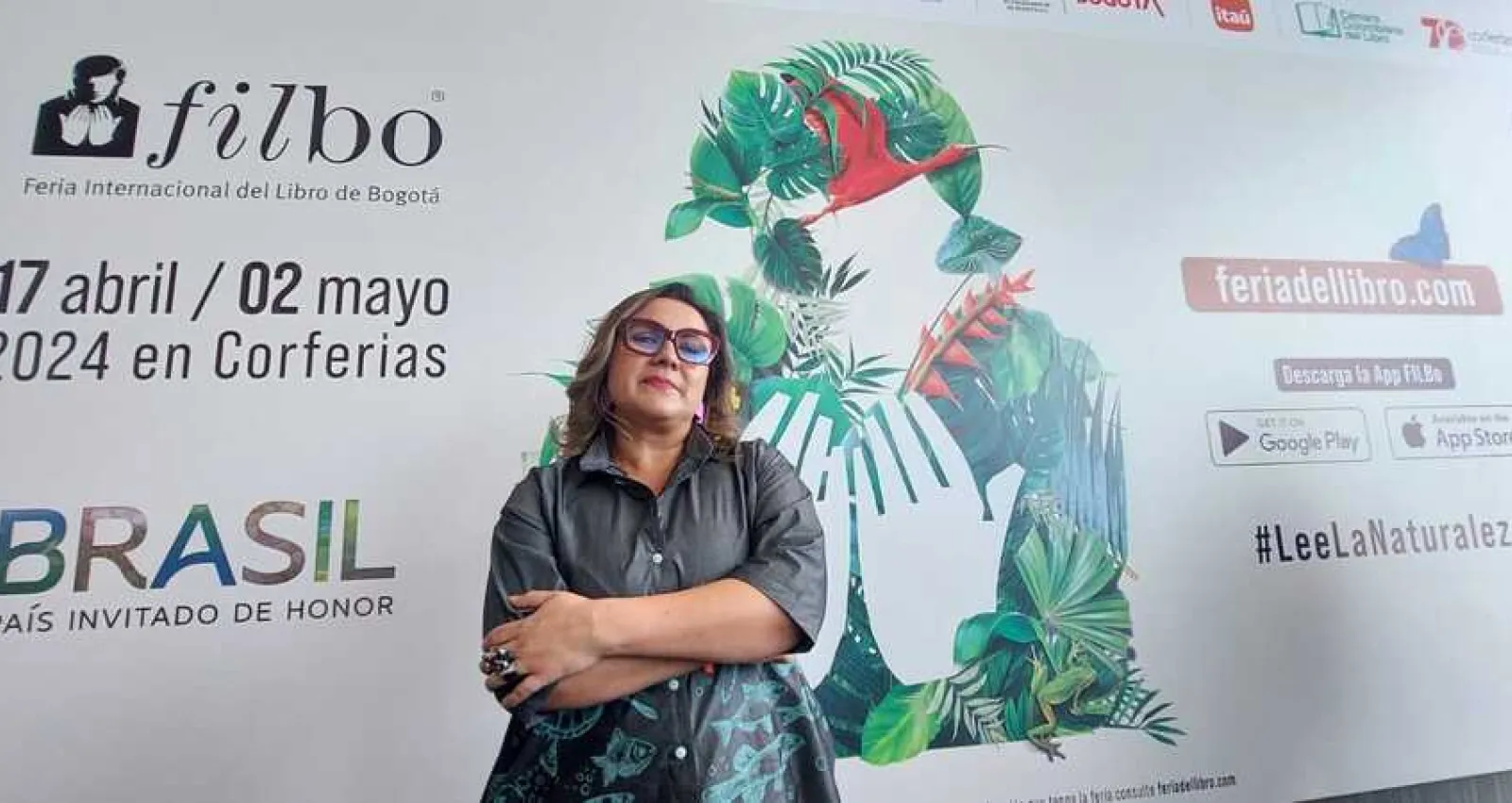 Foto de una mujer con gafas  rofas mirando a la cámara, plano americano