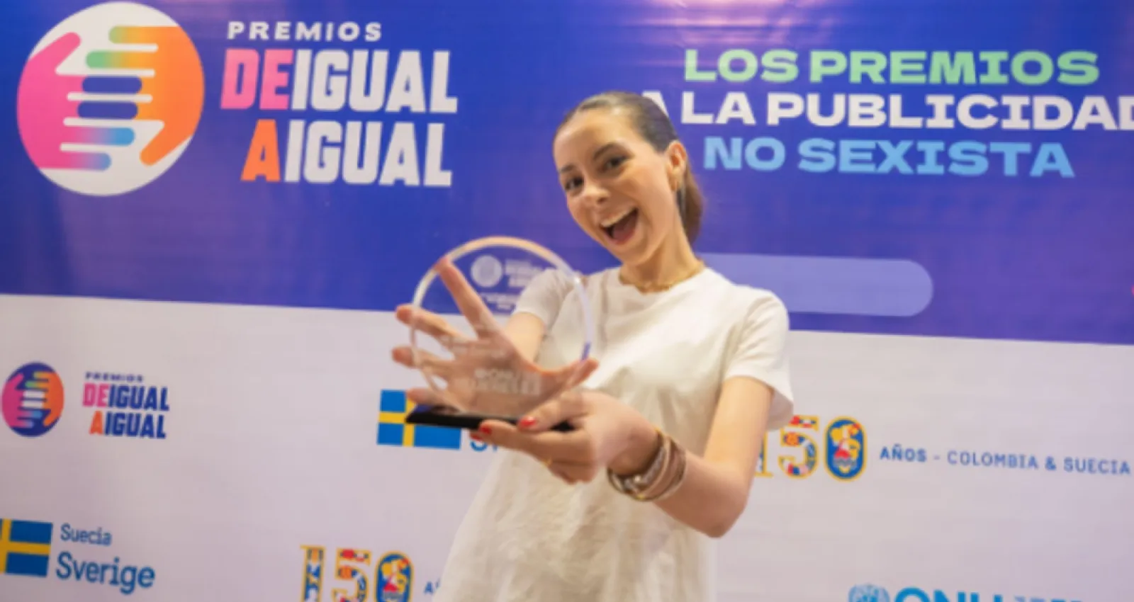 Foto de una mujer con un premio en sus manos 