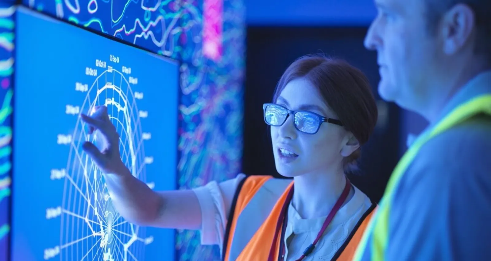 Foto de una mujer explicando un tema con una pantalla digital
