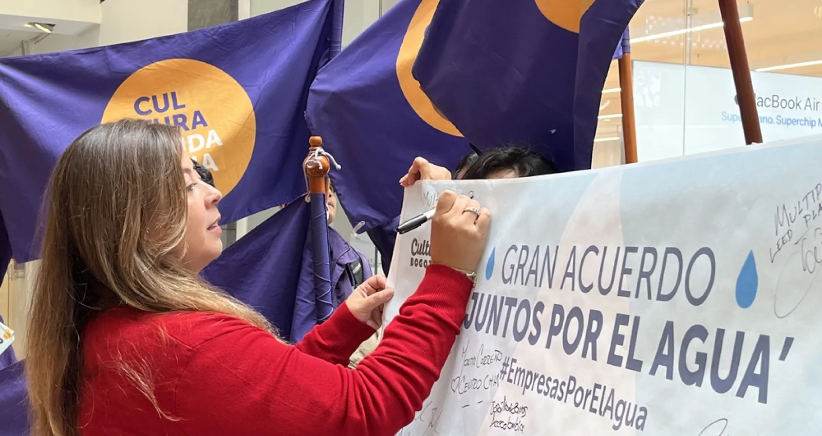Foto de una mujer firmando un acuerdo con la mano