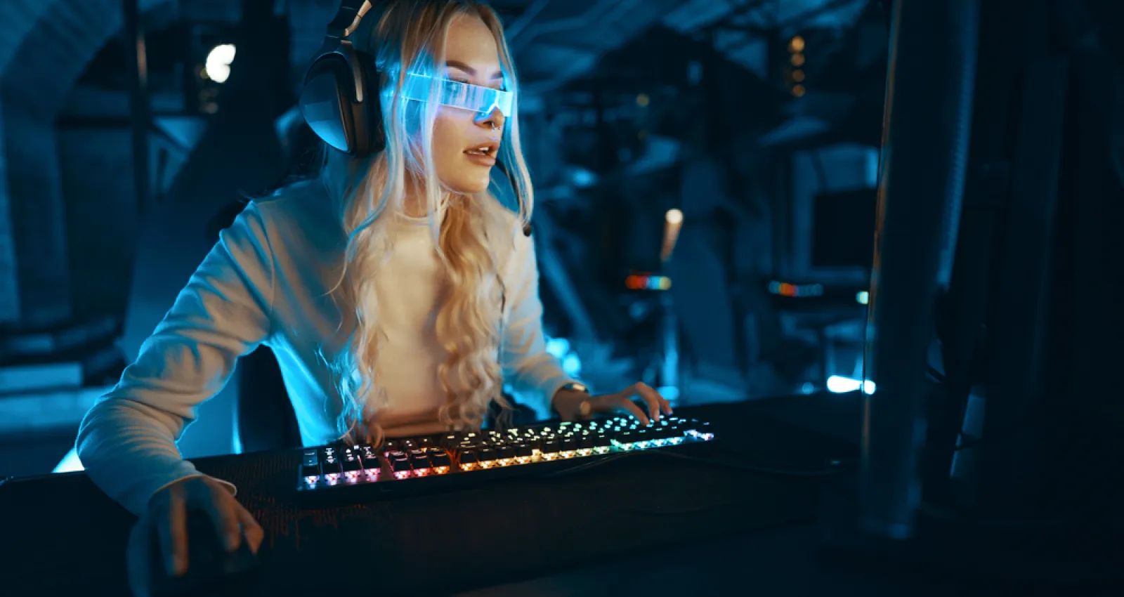 Foto de una mujer mirando un computador con unas gafas azules