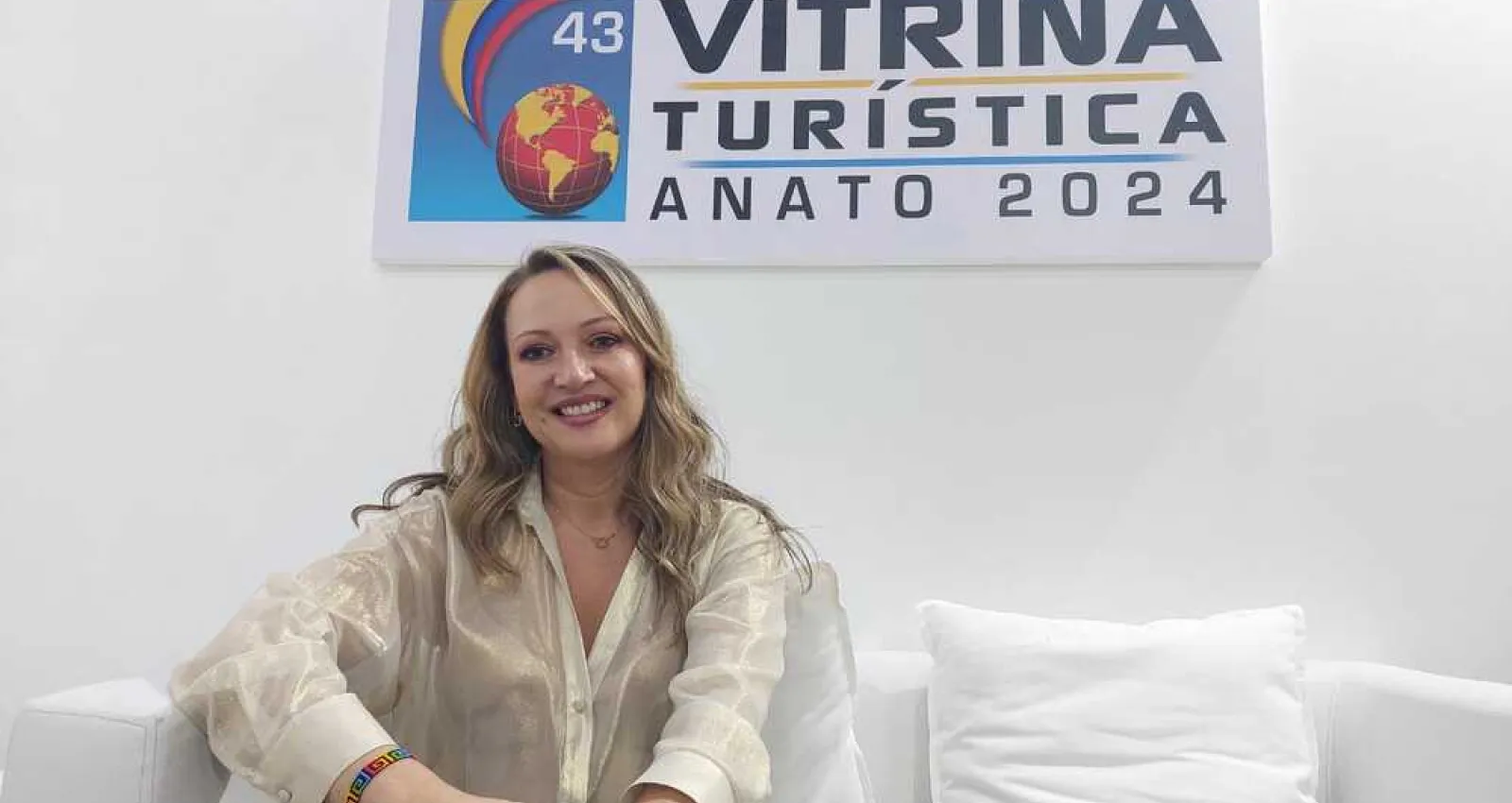Foto de una mujer sentada en un colchón con fondo blanco mirando a la cámara